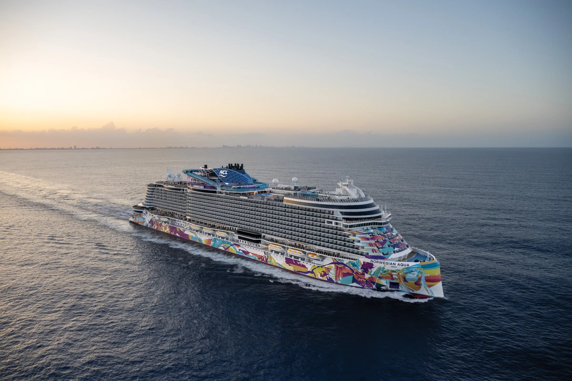 Norwegian Aqua cruise ship at sunset, part of Travel Squad Vacations' Norwegian Cruise Line specialty